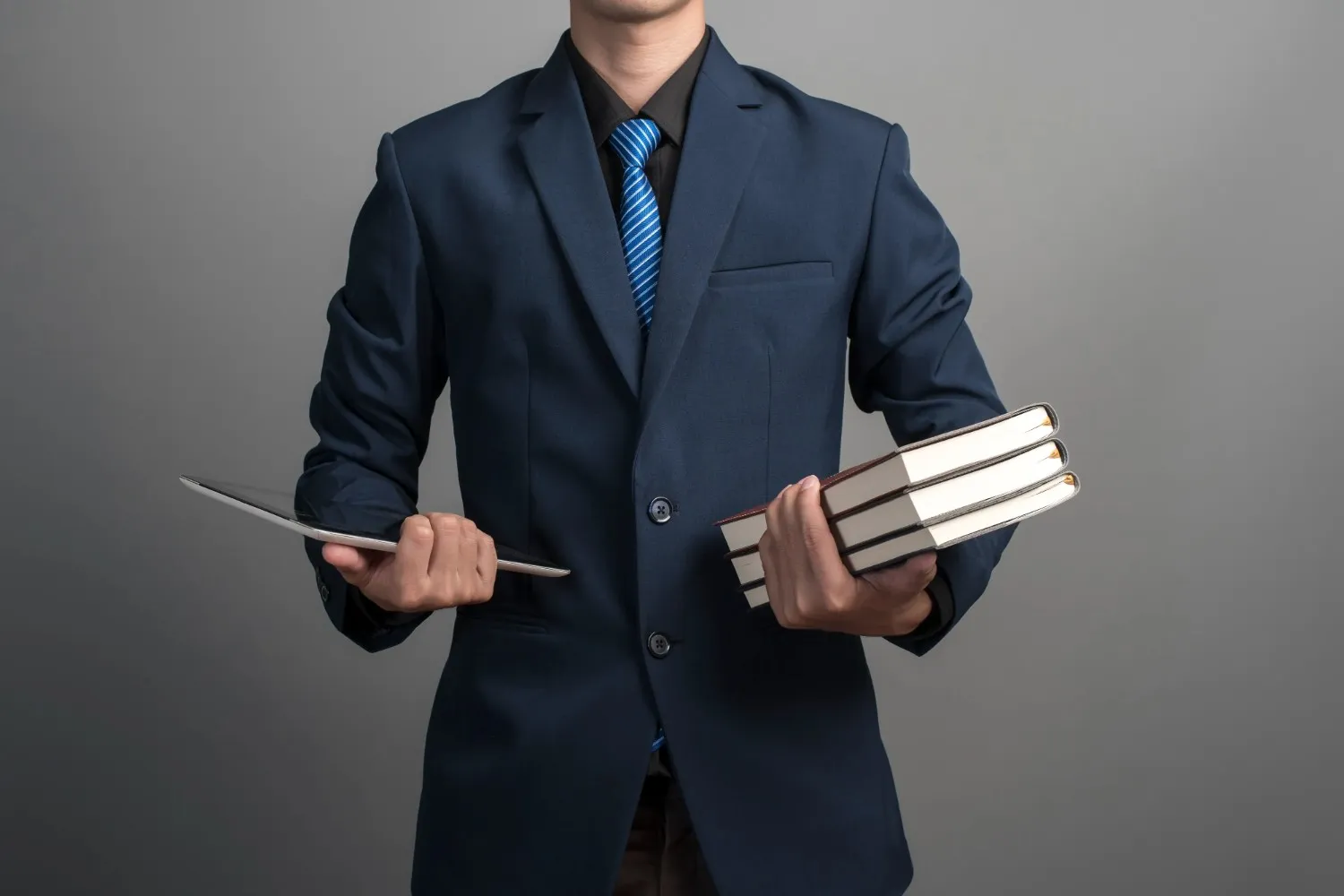 close-up-businessman-blue-suit-holding-books-gray-background