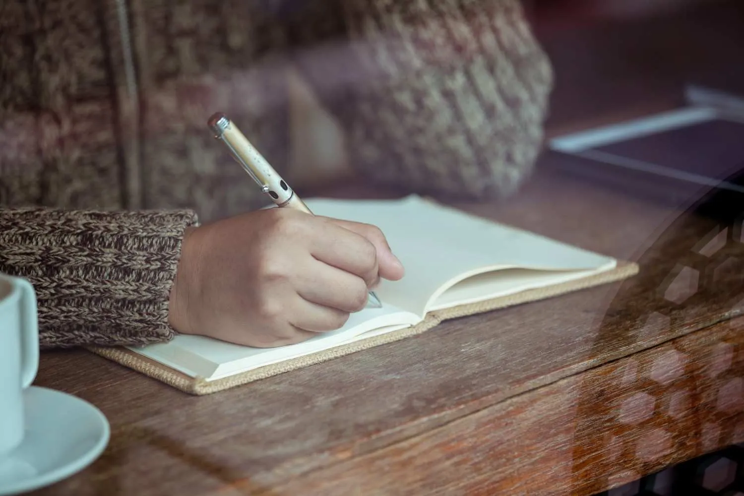 woman-writing-notebook-cafe-rainy-day-vintage-color-tone Canadian ghostwriters