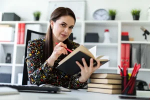 young-girl-sitting-office-computer-desk-working-with-book_webp- canadianghostwriters