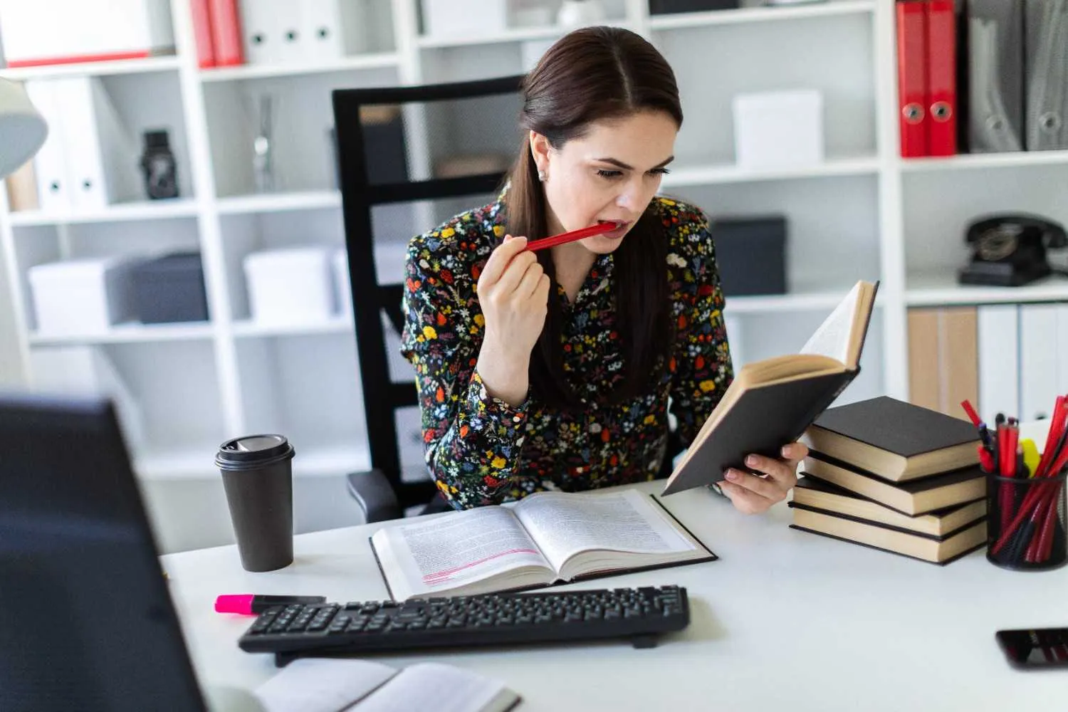young-woman-sitting-office-computer-desk-working-with-book- canadianghostwriters
