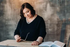 businesswoman-black-dress-with-beads-stands-desk-her-office-canadianghostwriters